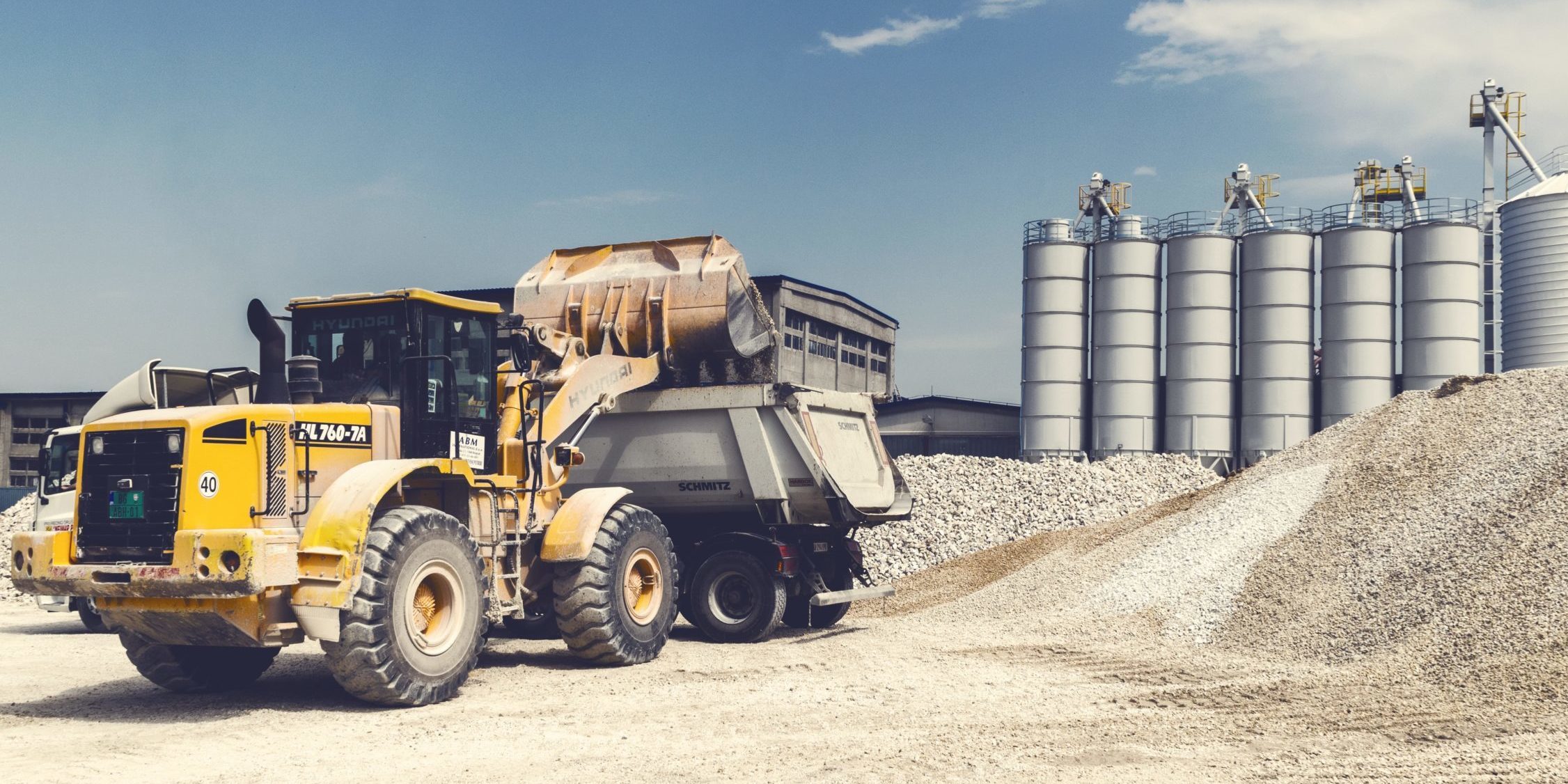 bucket loader dumping rocks into a dump truck